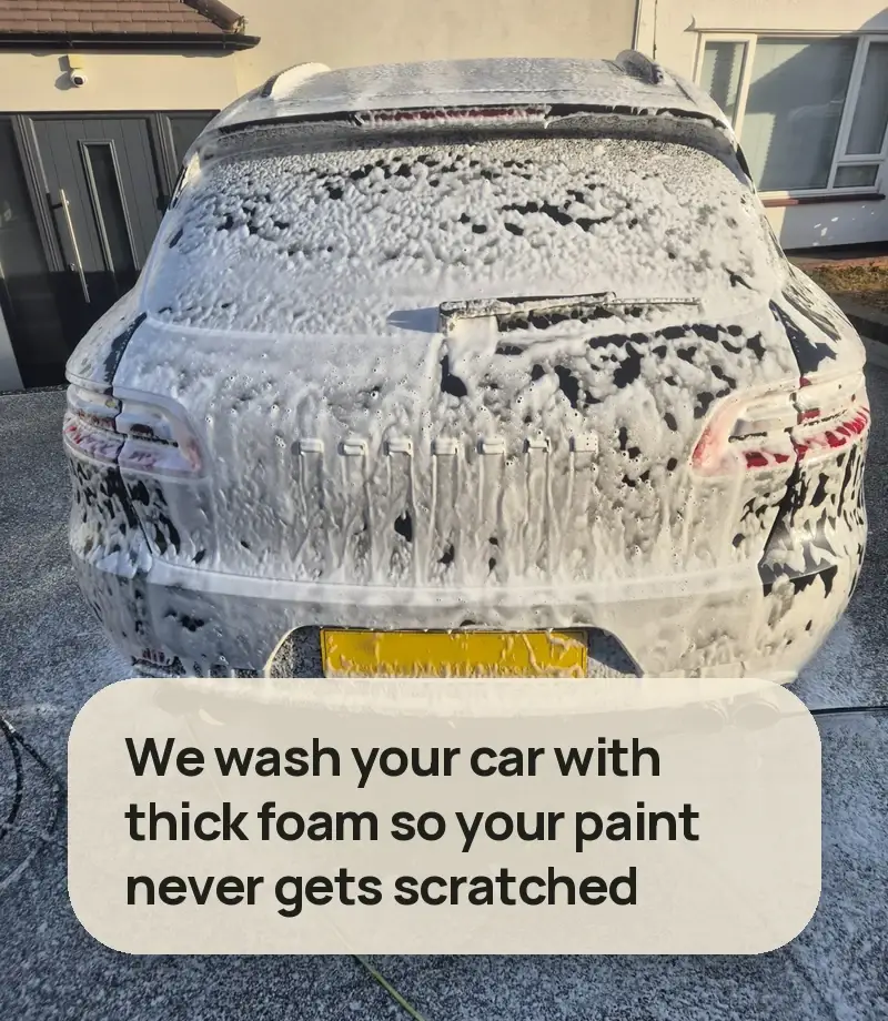 We wash your car with thick foam so your paint never gets scratched - rear of an SUV completely covered in snow foam