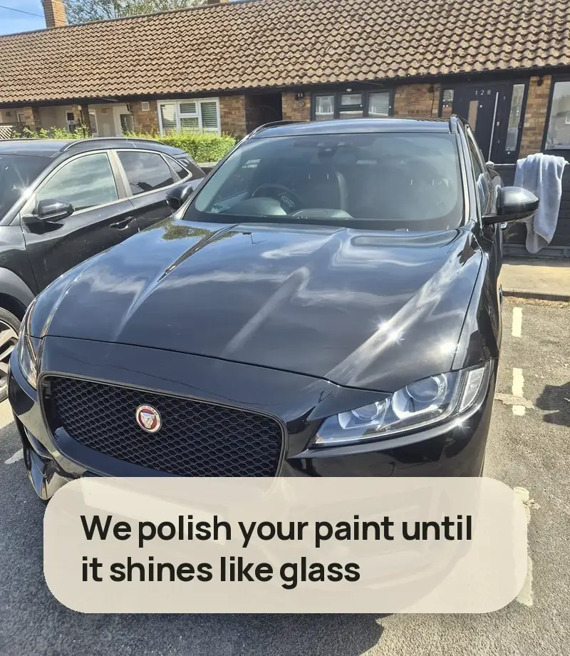 We polish your paint until it shines like glass - deep gloss black Jaguar F-Pace parked on a street