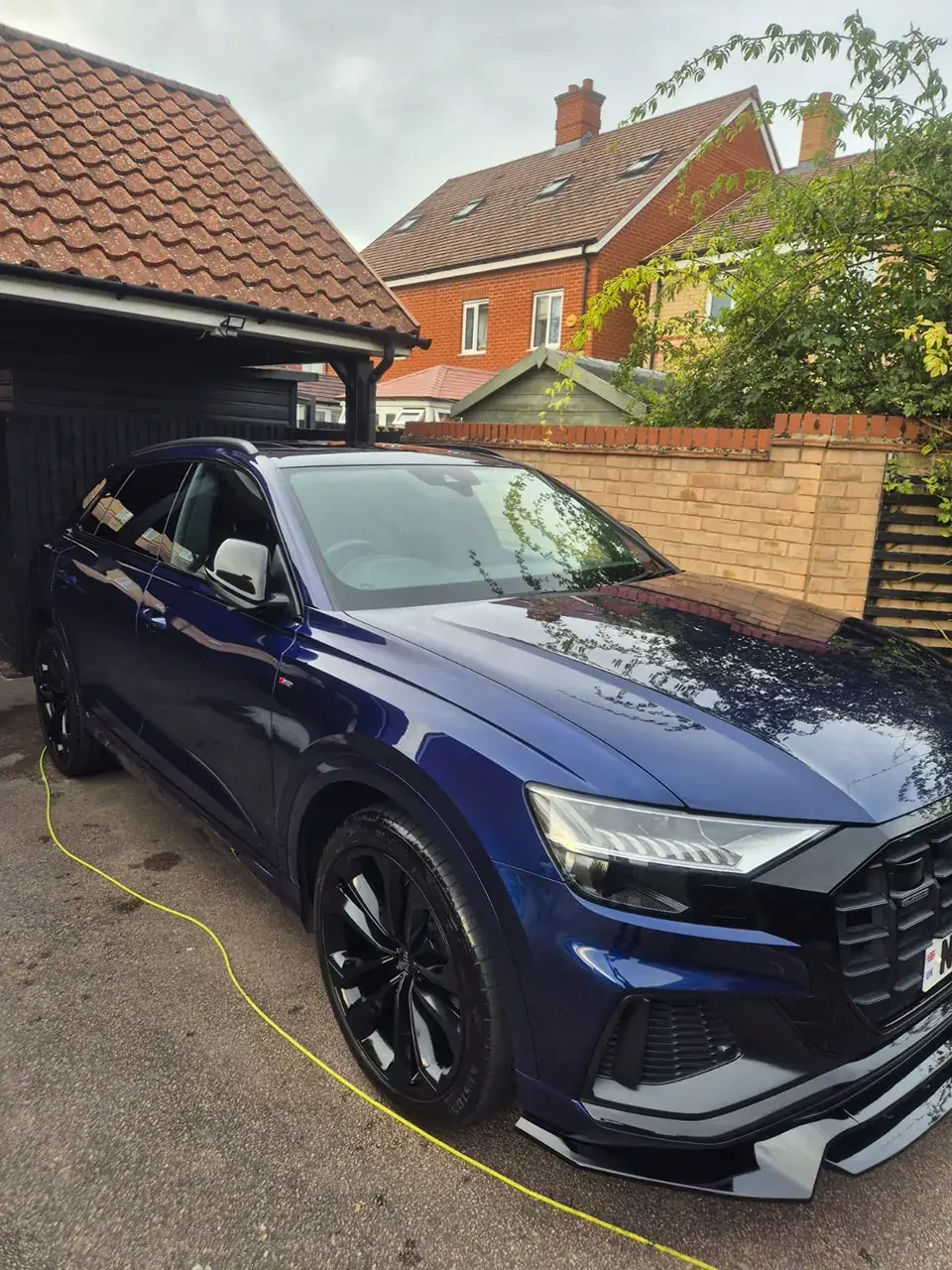 Dark blue Audi Q8 on a driveway with polished paint and black wheels