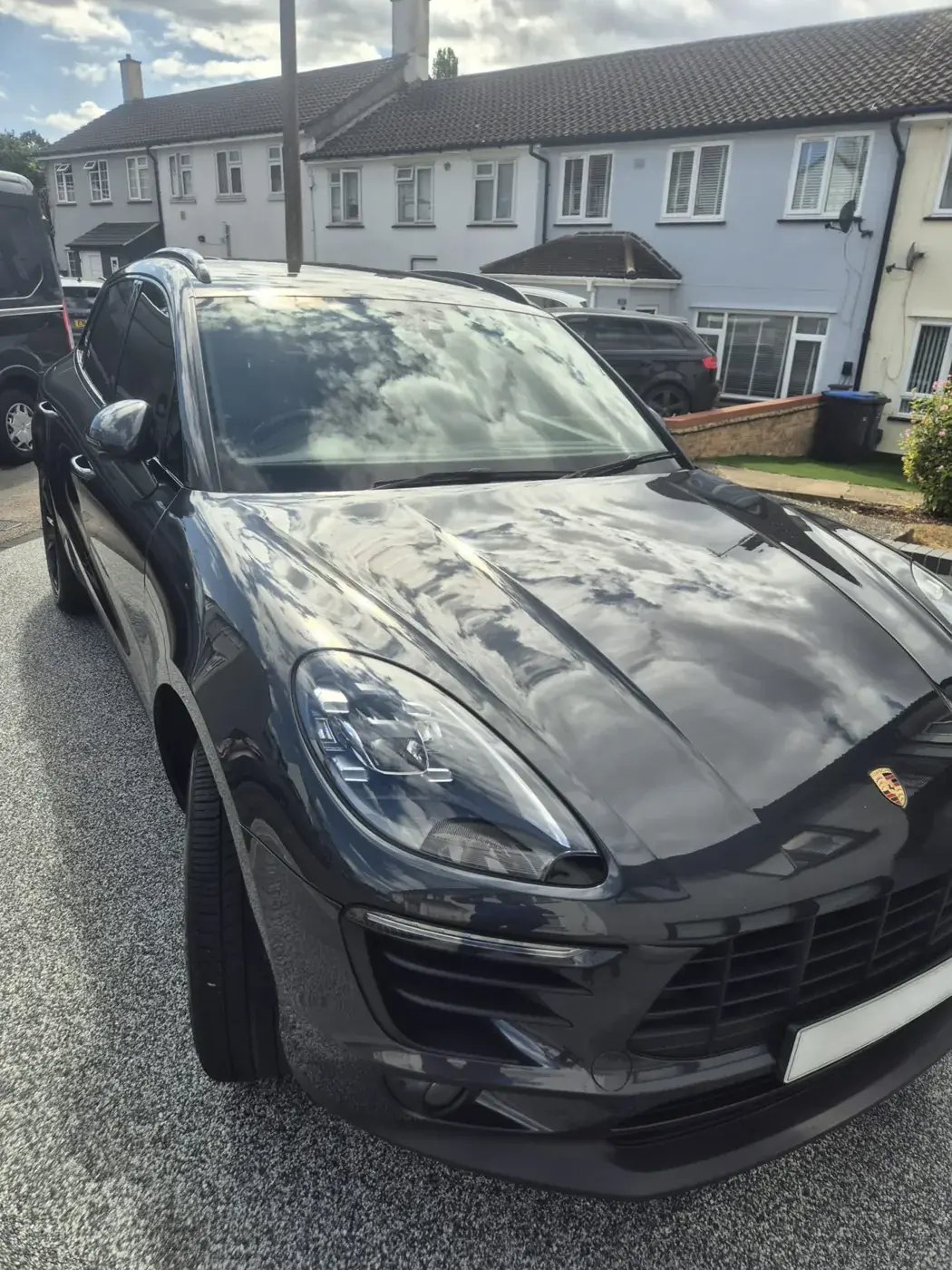 Black Porsche Macan on a gravel drive after cleaning